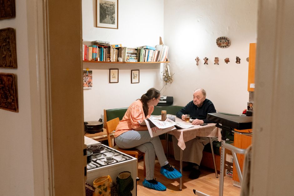 Warm scene of a caregiver and senior having a friendly conversation over coffee in Prague.